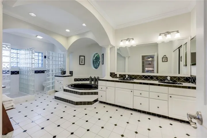 En suite primary bathroom with walk-in shower and soaking tub.