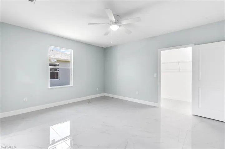 Spare room featuring a ceiling fan, baseboards, and marble finish floor