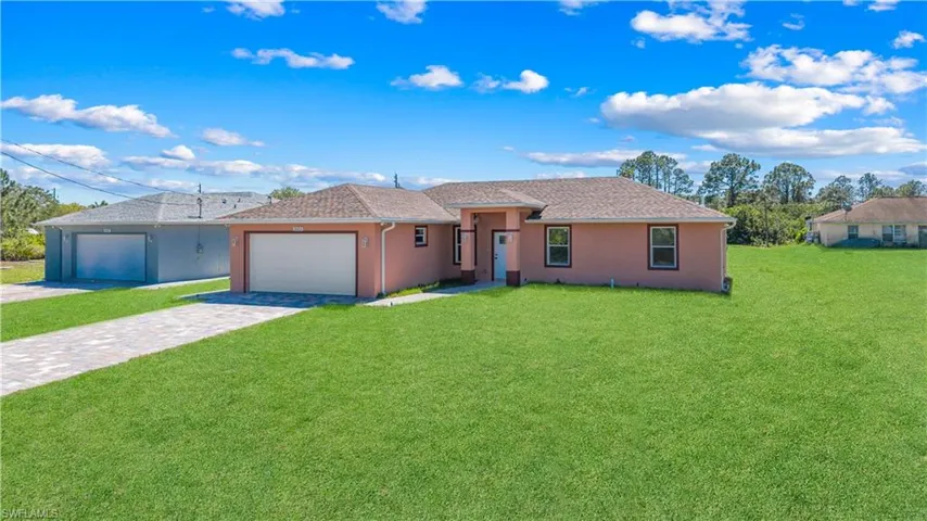 Ranch-style house featuring a garage, stucco siding, decorative driveway, and a front yard