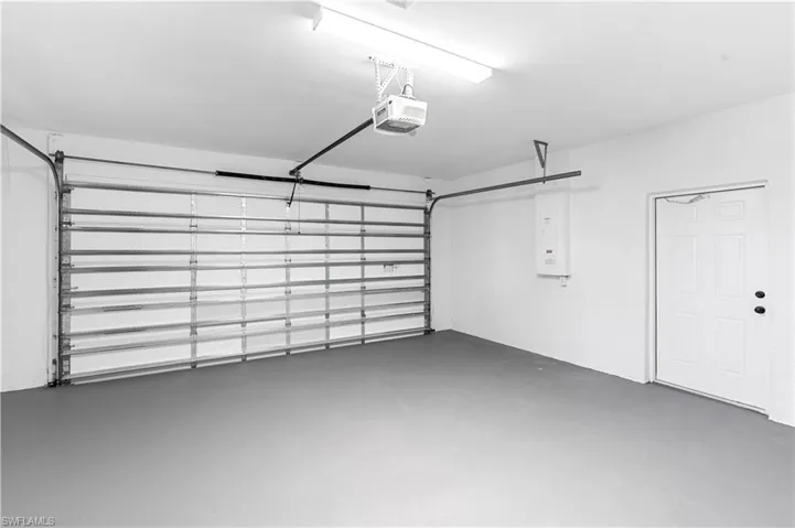 Garage featuring electric panel and a garage door opener