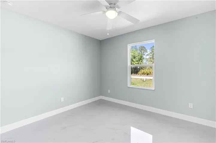 Spare room with a ceiling fan, baseboards, and marble finish floor