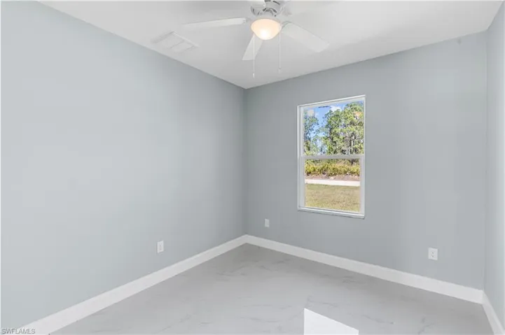 Empty room with visible vents, baseboards, marble finish floor, and ceiling fan