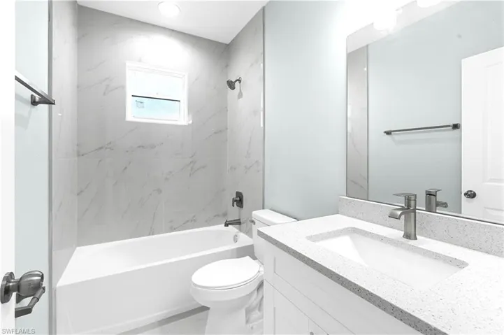 Bathroom featuring vanity, toilet, and shower / tub combination