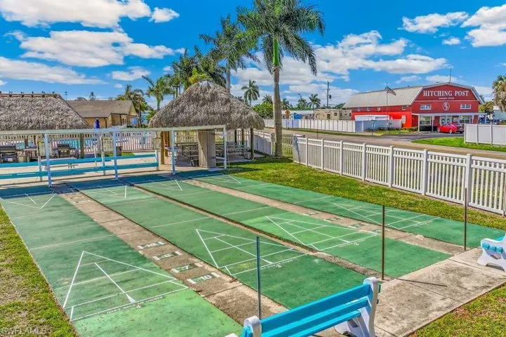 Community amenities featuring shuffleboard courts with multiple lanes and a white fence perimeter.