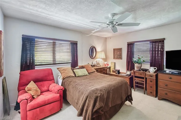 Carpeted bedroom featuring ceiling fan