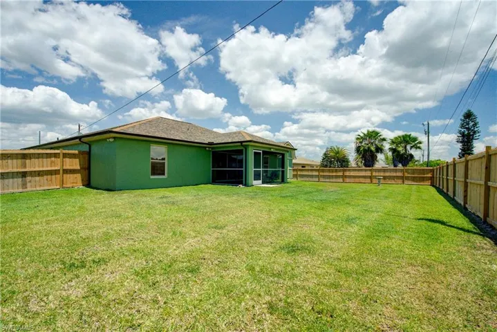 A vast backyard with a 6' tall wooden fence all the way around