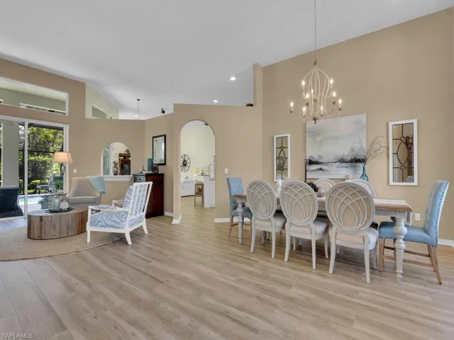 Dining room featuring light wood-type flooring, a chandelier, and high vaulted ceiling