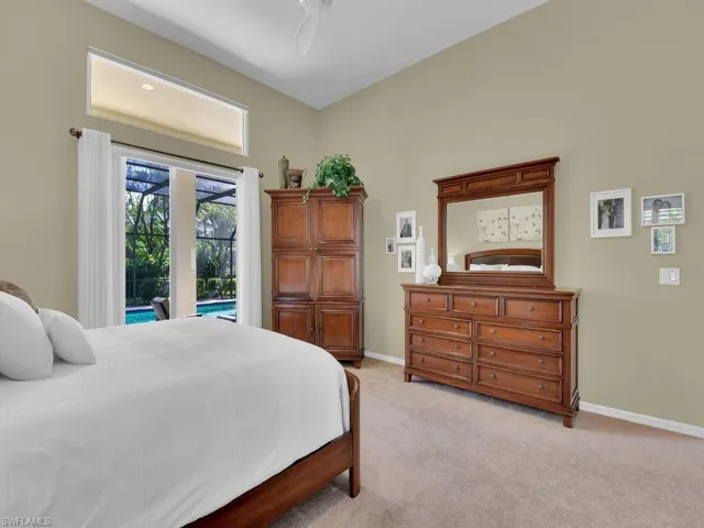 Carpeted bedroom with ceiling fan and access to exterior