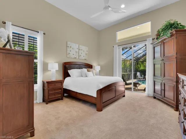 Carpeted bedroom featuring ceiling fan, access to exterior, and multiple windows