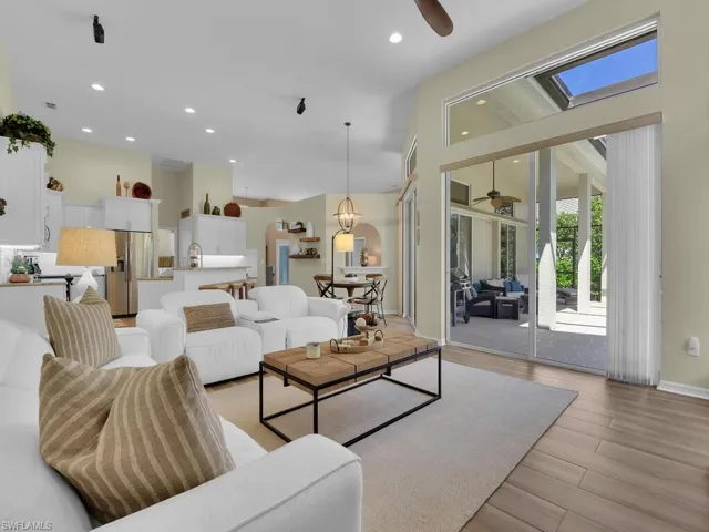 Living room featuring light wood-type flooring, ceiling fan, and a skylight