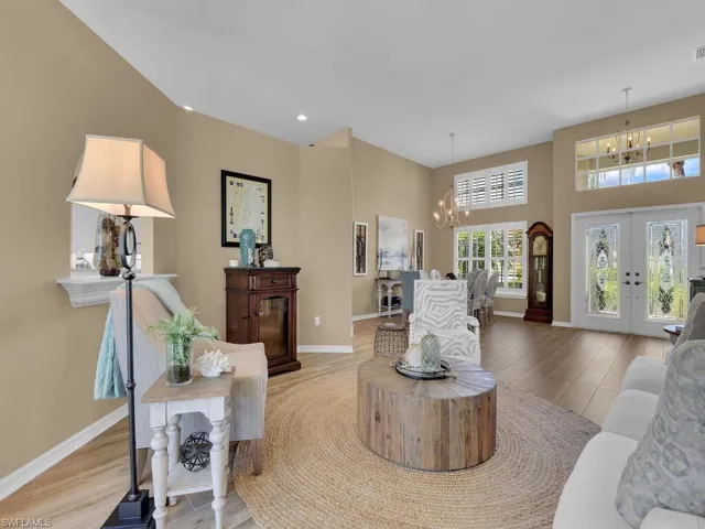 Living room with french doors, light hardwood / wood-style flooring, and a chandelier