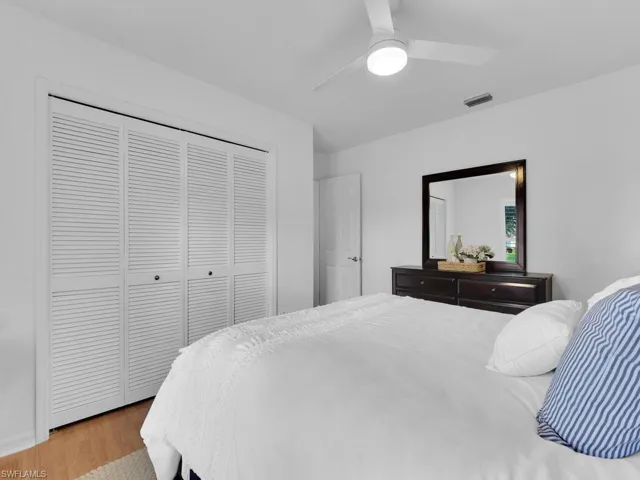 Bedroom with light hardwood / wood-style flooring, a closet, and ceiling fan