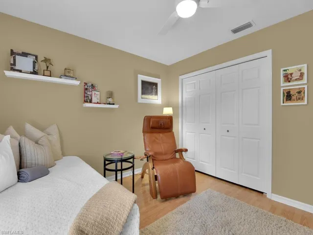 Bedroom with hardwood / wood-style floors, ceiling fan, and a closet