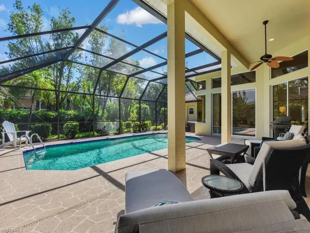 View of swimming pool featuring a grill, a lanai, ceiling fan, and a patio area