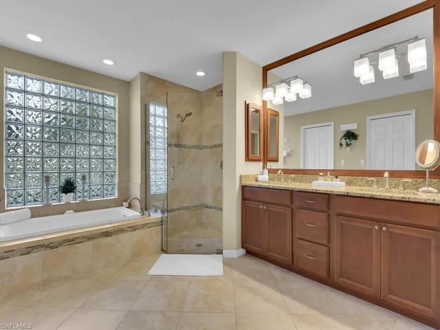 Bathroom with tile patterned floors, vanity, and separate shower and tub