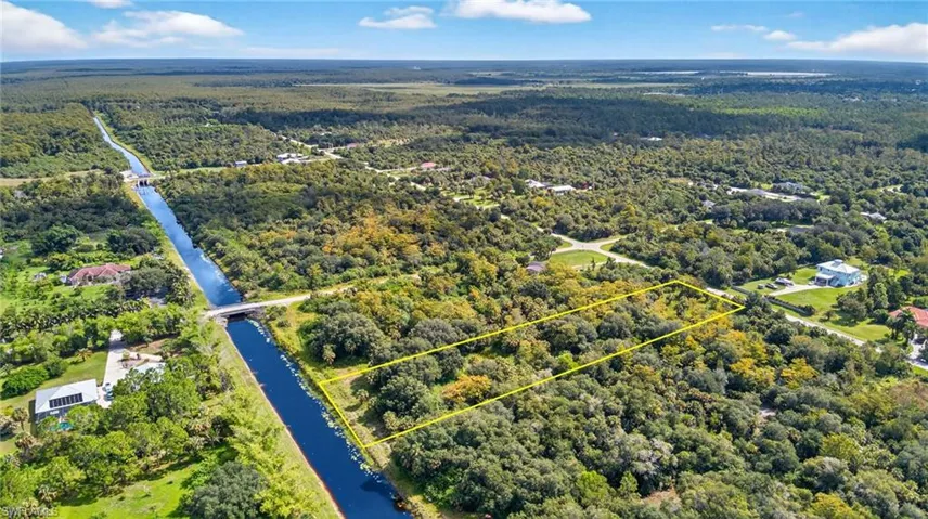 Aerial view of property and surrounding area featuring property parcel outlined and a large body of water