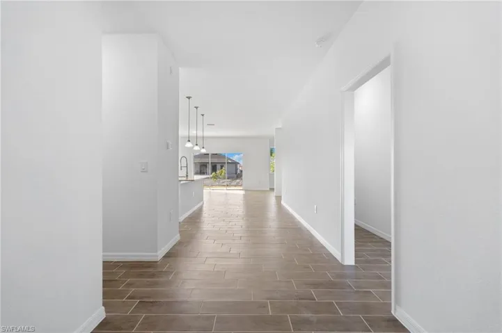 Hall with baseboards and wood finish floors