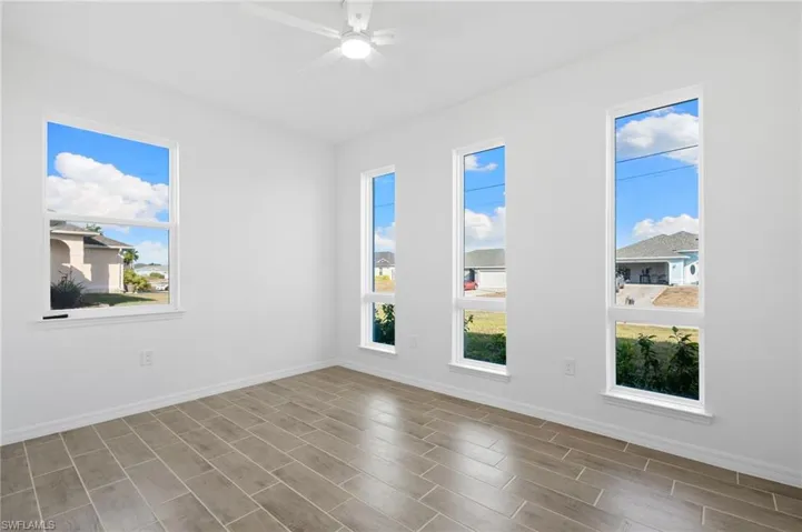 Unfurnished room featuring wood tiled floors and a ceiling fan