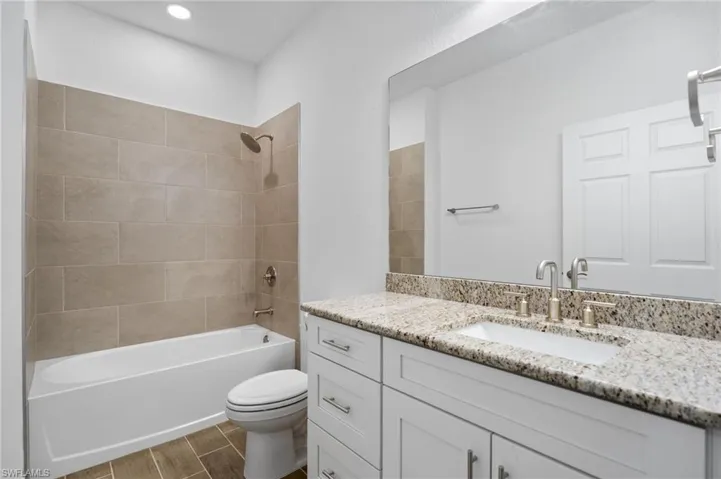 Full bathroom with shower / bathtub combination, vanity, and wood tiled floors