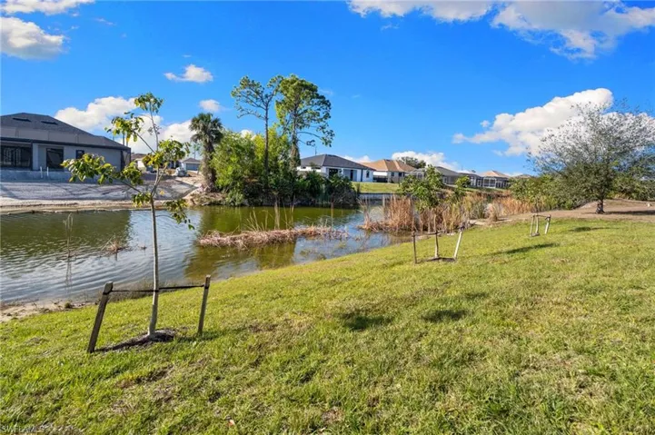 View of green lawn with a water view and a residential view