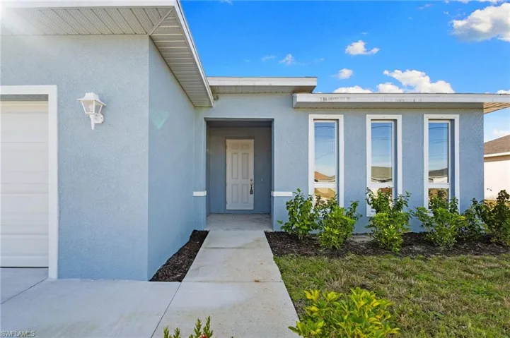 Entrance to property with stucco siding