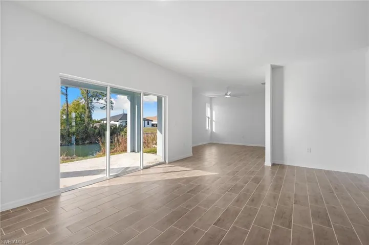 Empty room with wood tiled floors and a ceiling fan