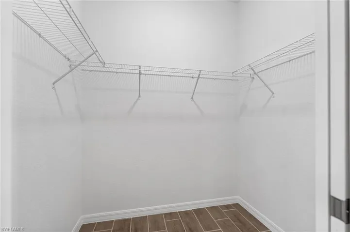 Walk in closet with wood tiled floors
