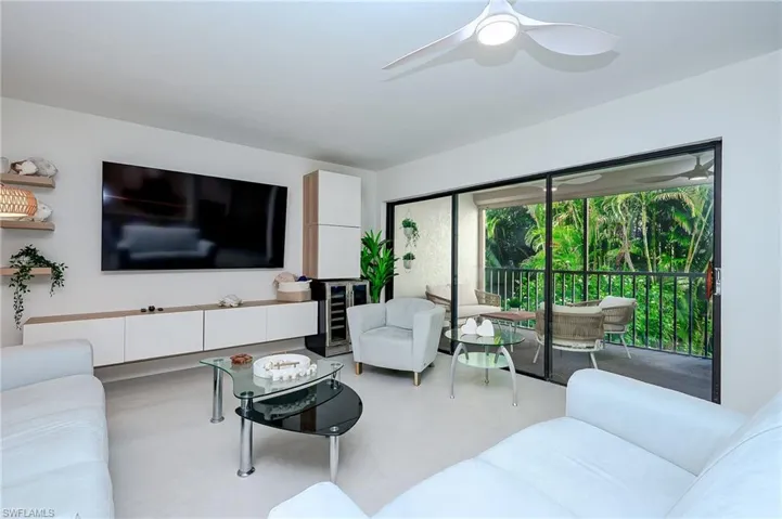 Living area featuring finished concrete floors and a ceiling fan
