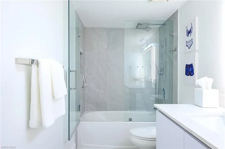 Full bath featuring vanity and bath / shower combo with glass door