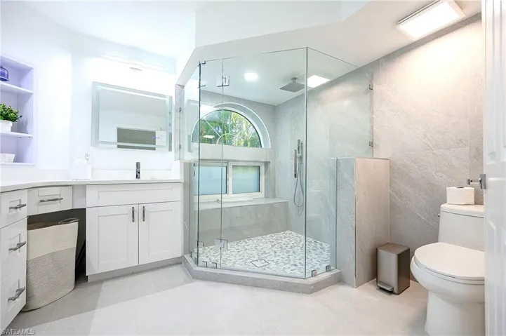 Full bathroom featuring vanity, a stall shower, and light tile patterned floors