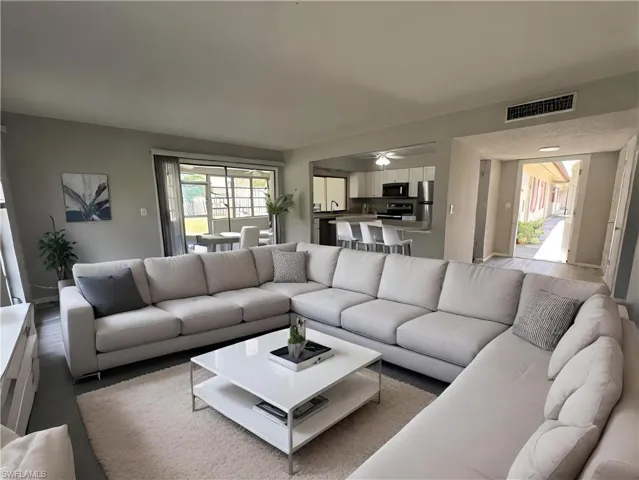 Living room with hardwood / wood-style flooring, plenty of natural light, and ceiling fan