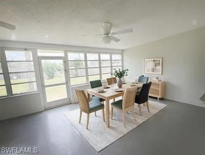 Enclosed space with expansive windows, light gray walls, and a ceiling fan