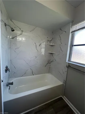 Bathroom featuring hardwood / wood-style flooring and tiled shower / bath combo
