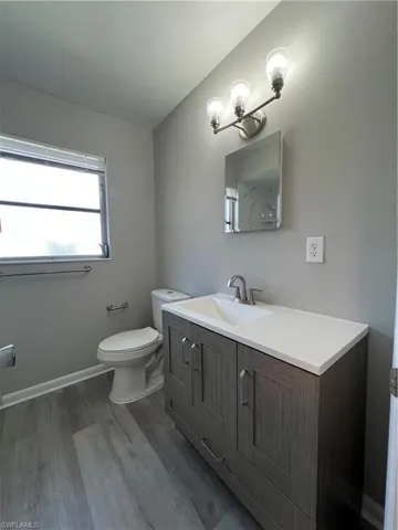 Bathroom with wood-type flooring, vanity, and toilet