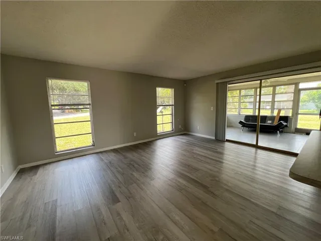 Spare room featuring a textured ceiling and dark hardwood / wood-style floors