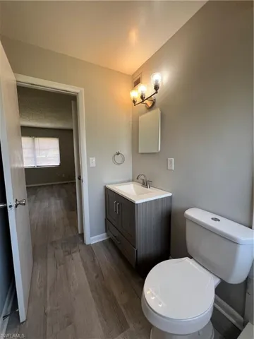 Bathroom featuring hardwood / wood-style flooring, vanity, and toilet