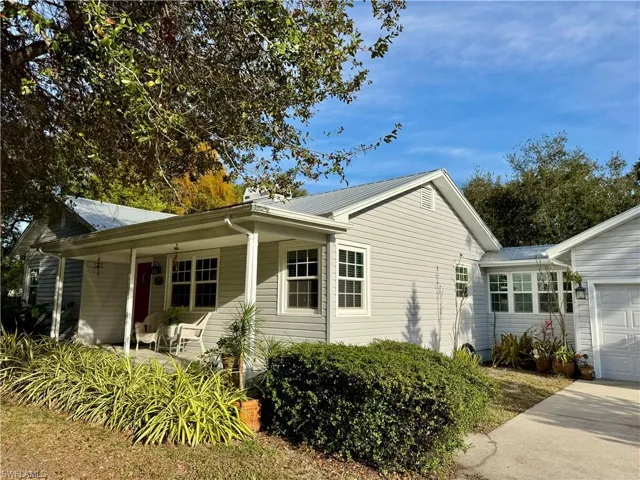 View of side of home with covered porch and a garage