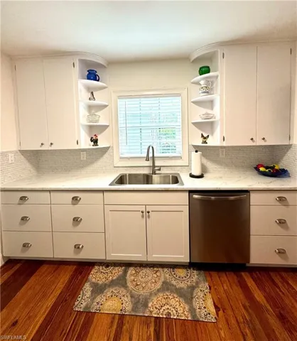 Kitchen featuring open shelves, backsplash, and white cabinets
