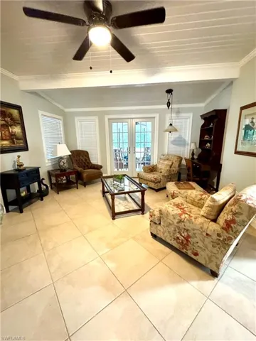 Living area featuring crown molding, french doors, and tile floors