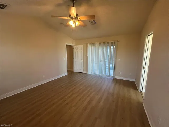 Empty room featuring ceiling fan, lofted ceiling, and wood finished floors