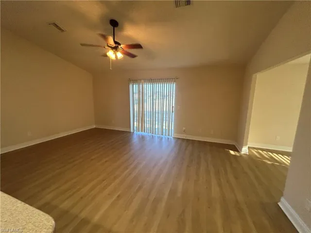 Unfurnished room featuring dark wood-style floors and a ceiling fan