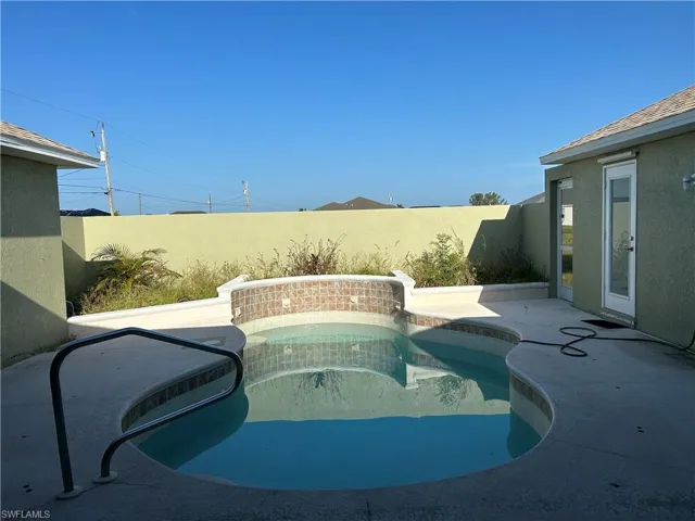 View of pool featuring patio surround and a fenced backyard