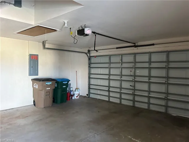 Garage featuring electric panel and a garage door opener
