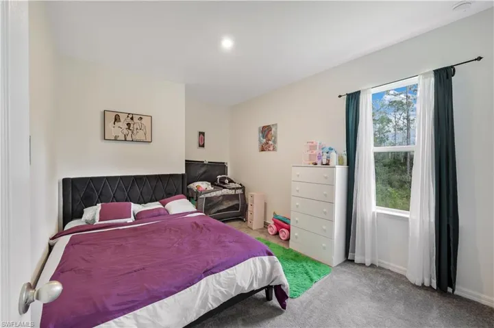 Carpeted bedroom with multiple windows
