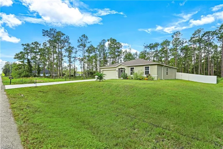 Single story home with a garage and a front lawn