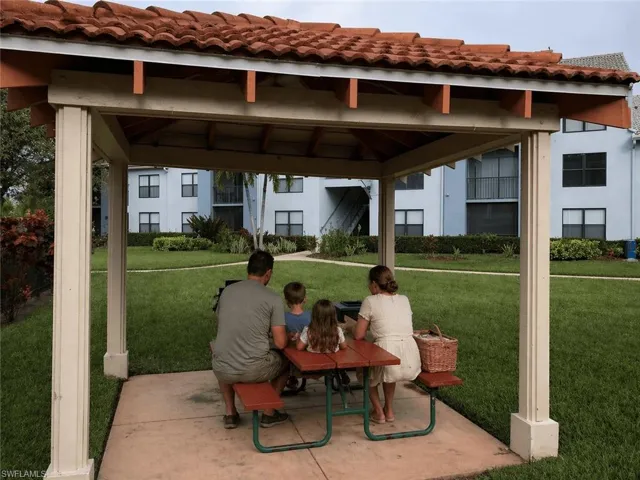 Outdoor pavilion featuring a red tile roof, supporting columns, and a concrete pad