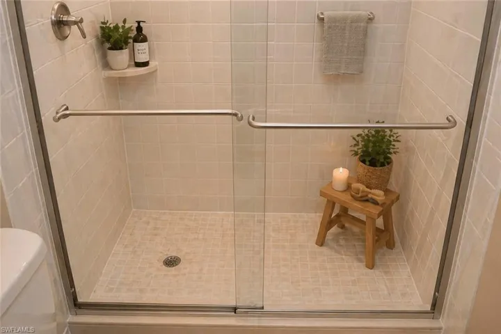 Glass-enclosed shower featuring subway tile walls and a mosaic tile floor