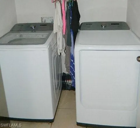 Laundry room featuring washer and dryer and light tile patterned floors