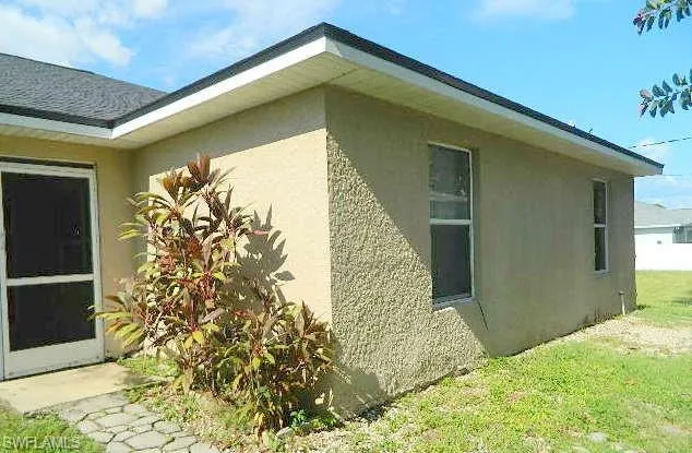 View of property exterior featuring stucco siding and a lawn
