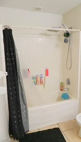 Bathroom with shower / bath combo and light tile patterned floors